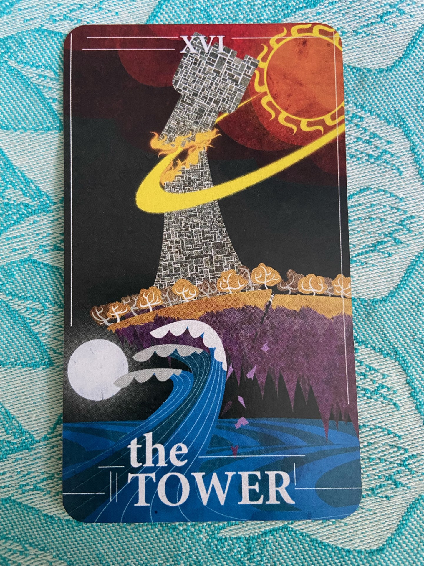 The Tower tarot card depicting a tower struck by lightning with figures falling from it