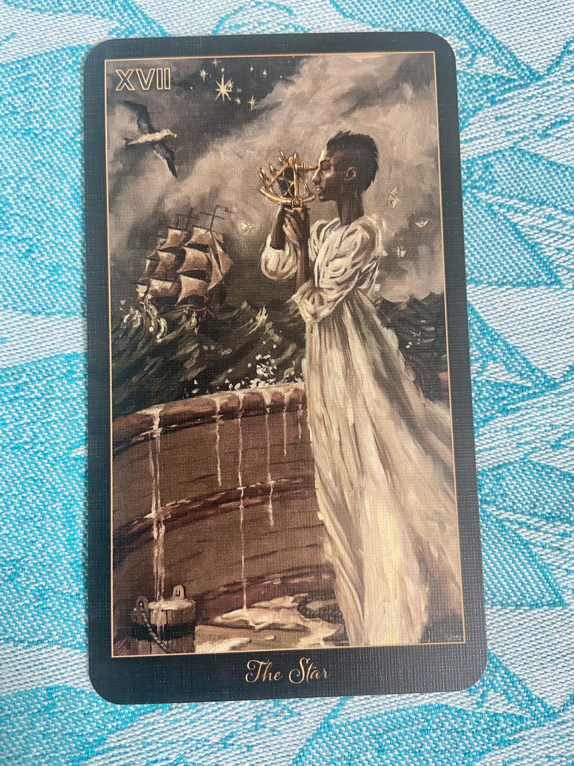The Star tarot card featuring a woman pouring water from two jugs under a starry sky